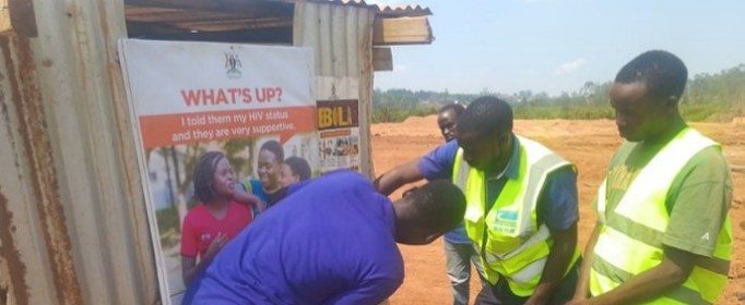 Community volunteers display IEC materials on health prevention beside a village shelter