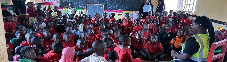 Pupils in red uniforms at a school health session in Wakiso